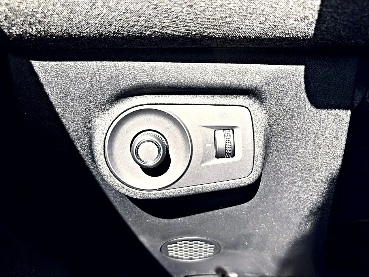 Gros plan sur la commande de réglage des rétroviseurs dans l’habitacle noir du MG Motor ZS 1.5 hybrid 197 standard.