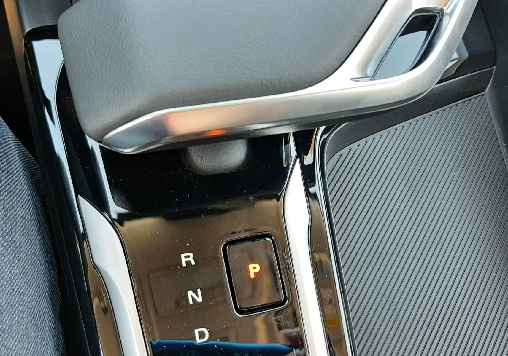 Gros plan sur la console centrale noire brillante du MG ZS 1.5 Hybrid+ 2026 avec levier de vitesses automatique et bouton P illuminé.