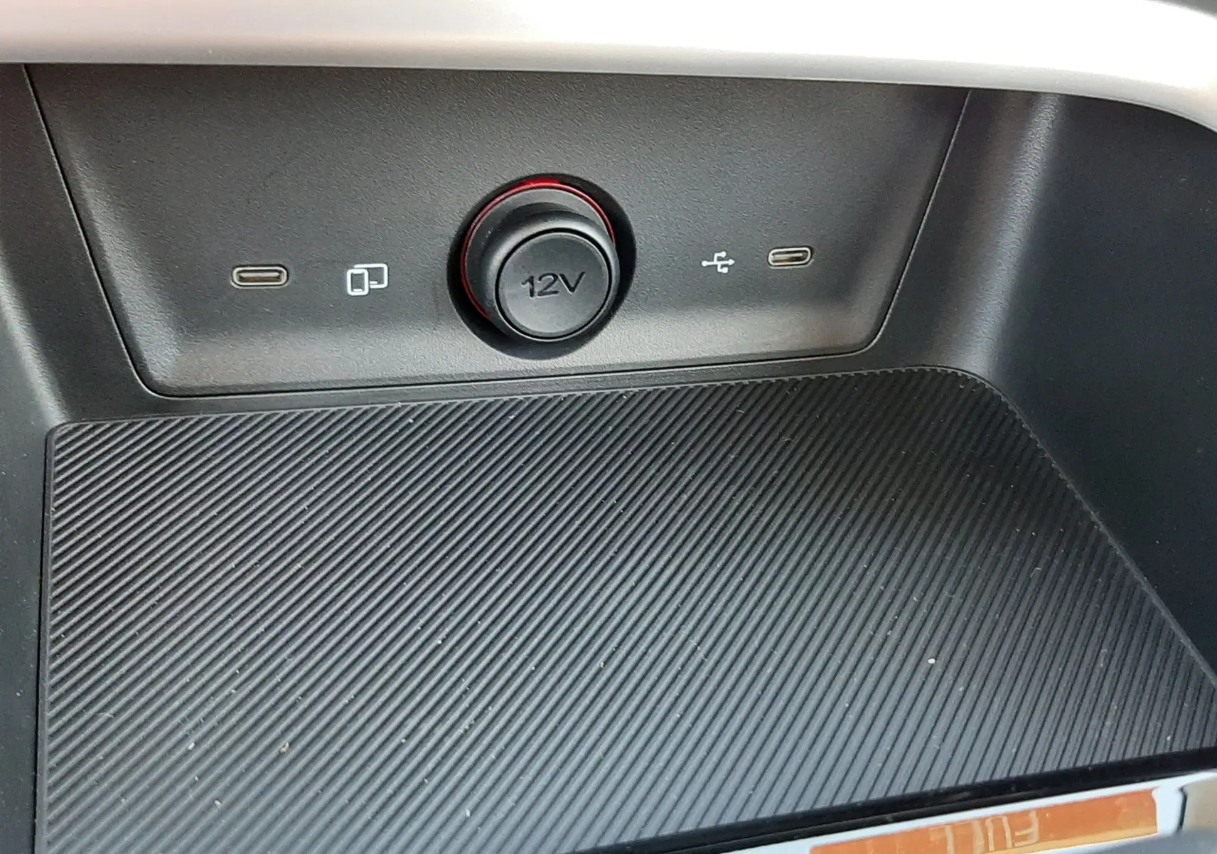 Gros plan sur la console centrale noire du MG ZS 1.5 Hybrid+ 197ch Comfort avec prise 12V et ports USB visibles.