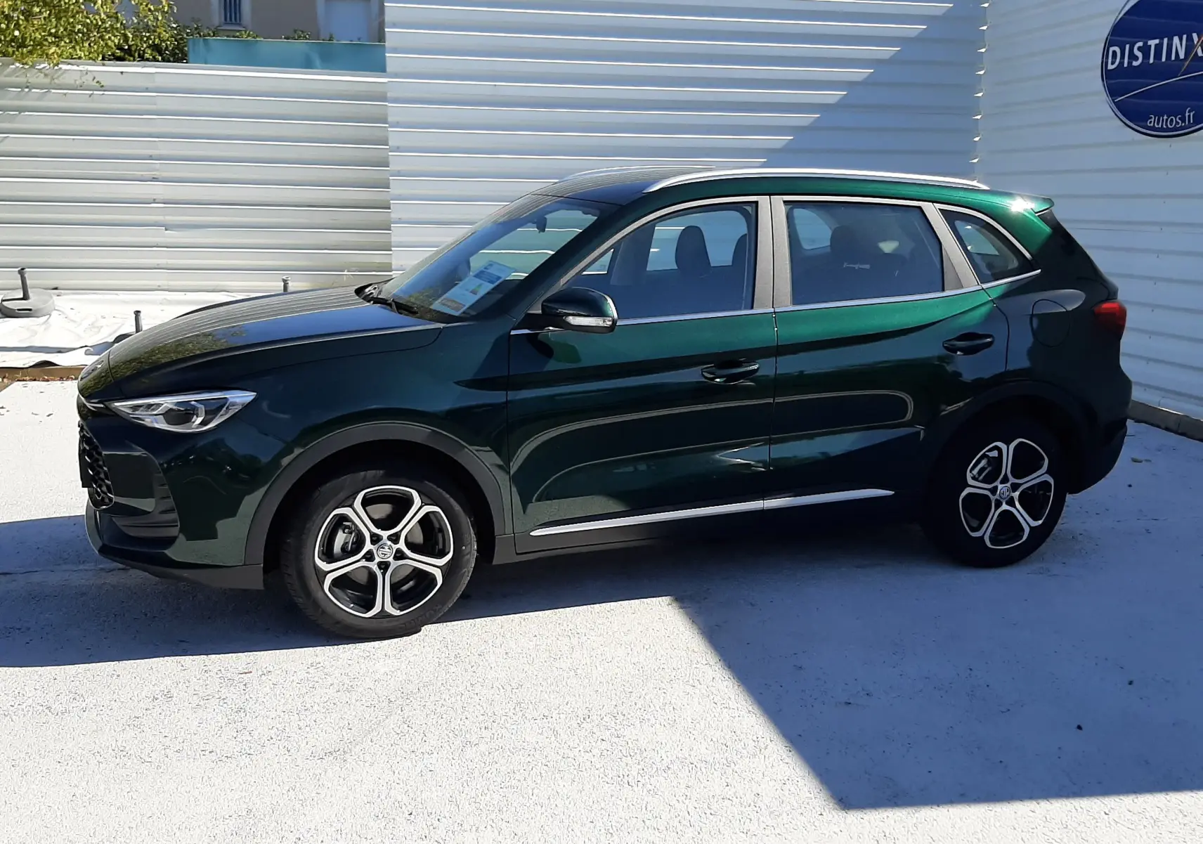 Vue de profil côté gauche du SUV MG ZS 1.5 Hybrid+ 197ch en vert émeraude avec jantes alliage bicolores.
