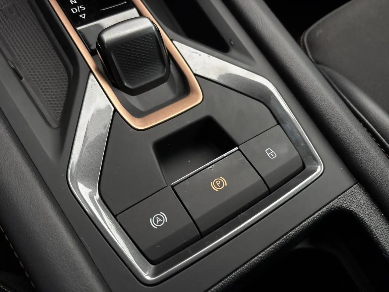 Gros plan sur la console centrale noire et grise du CUPRA LEON ST 2025 avec levier de vitesse et boutons de frein électrique.