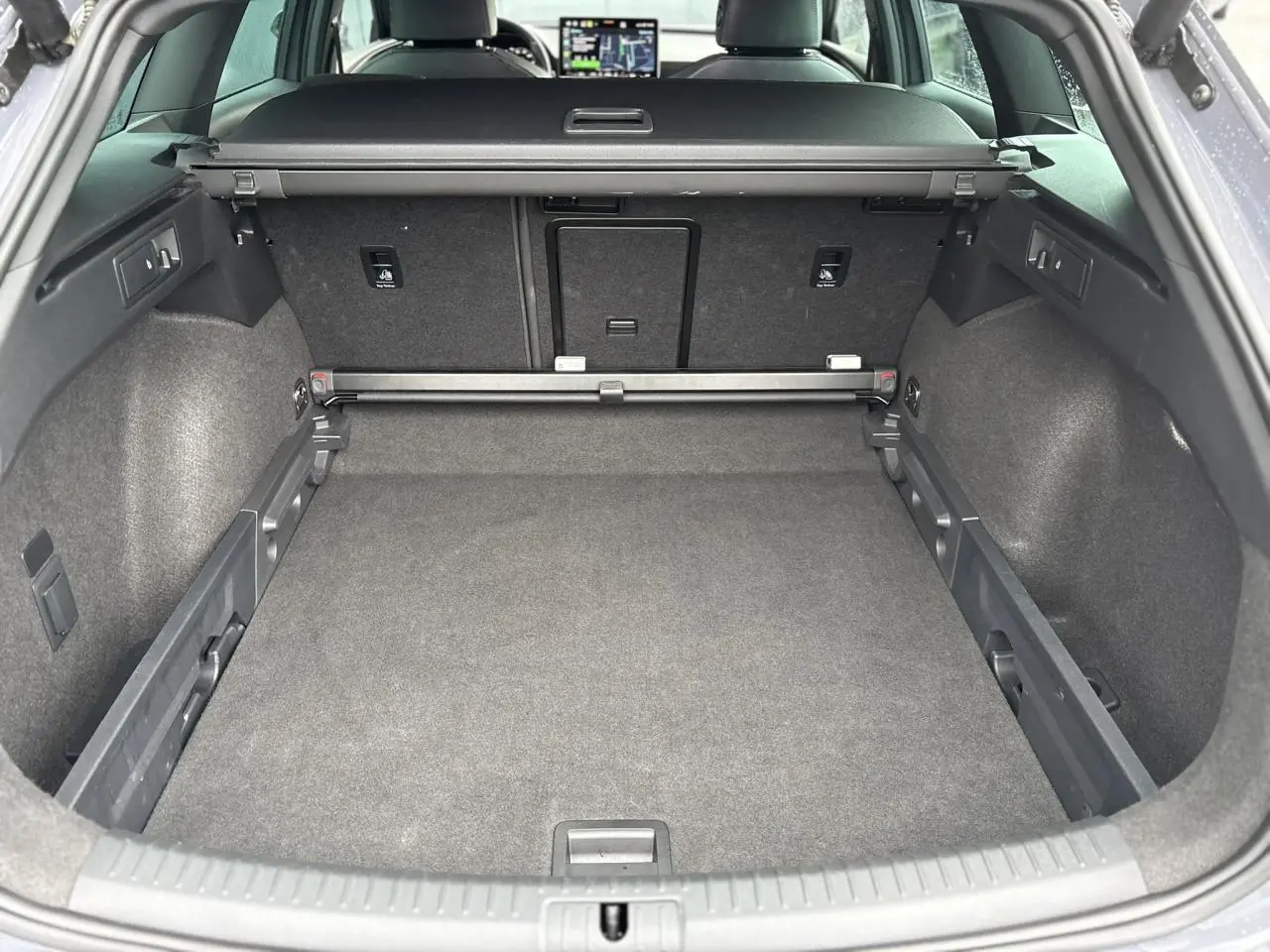 Coffre spacieux vu de l'arrière ouvert du CUPRA LEON ST gris Graphene avec banquette arrière et tablette arrière visible.