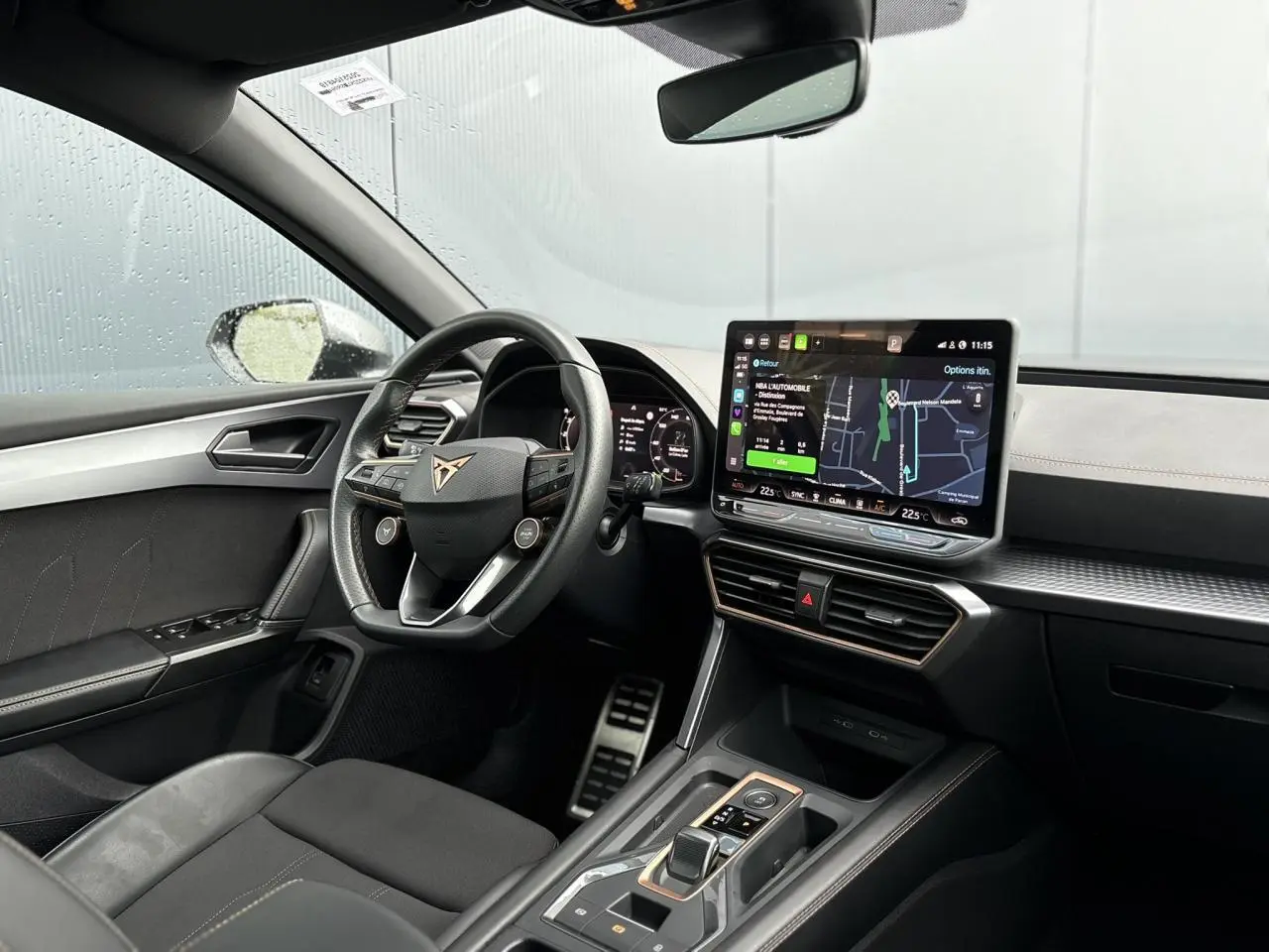 Vue intérieure côté conducteur du CUPRA LEON ST 2025 avec tableau de bord numérique et écran tactile central affichant la navigation.