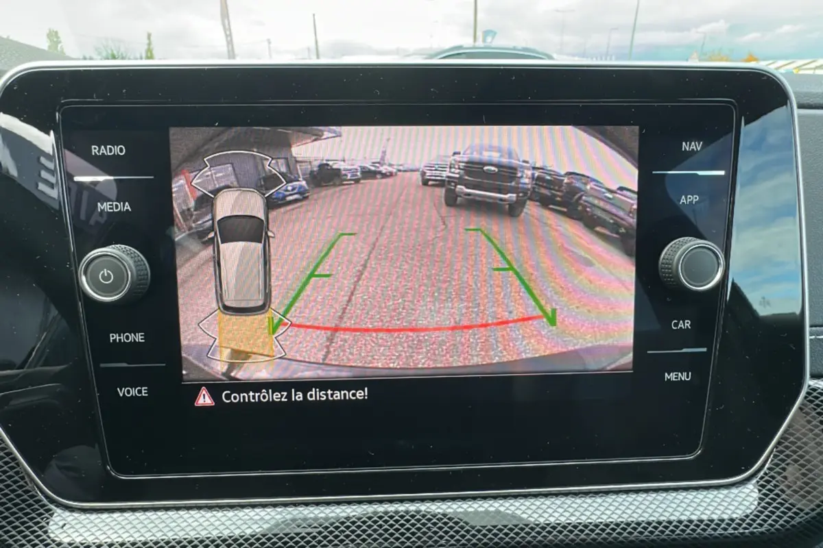 Écran multimédia affichant la caméra de recul du Volkswagen T-Cross noir intense, avec guidage de trajectoire verte et rouge.