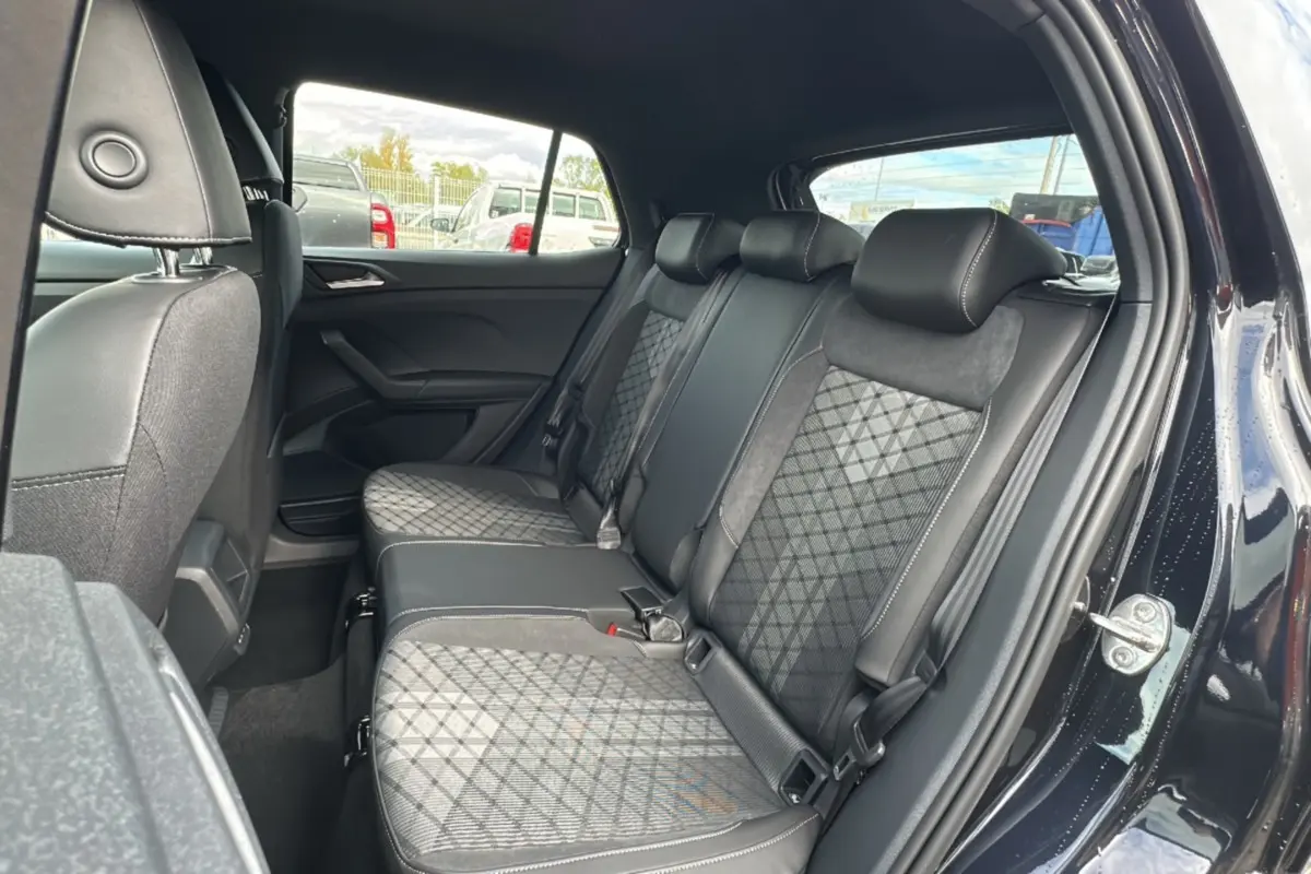 Vue intérieure côté droit sur la banquette arrière en tissu noir à motifs géométriques du Volkswagen T-Cross noir intense.