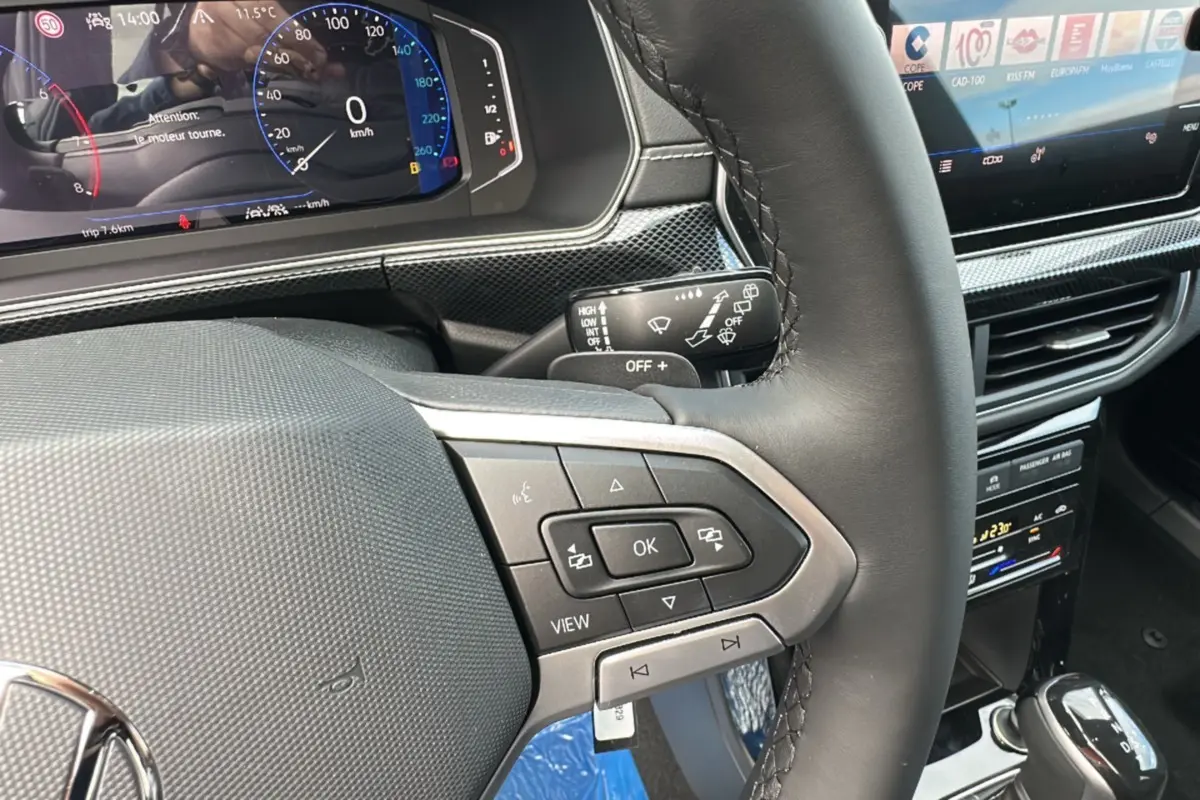 Gros plan sur le volant cuir multifonctions et le tableau de bord numérique du Volkswagen T-Cross TSI 116 DSG7 R-Line 2025 noir intense.