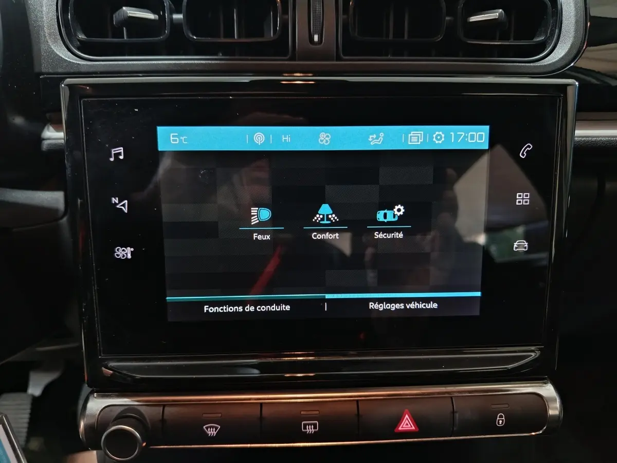 Écran tactile central de la Citroën C3 gris foncé, affichant les réglages de conduite et sécurité, vue rapprochée intérieure.