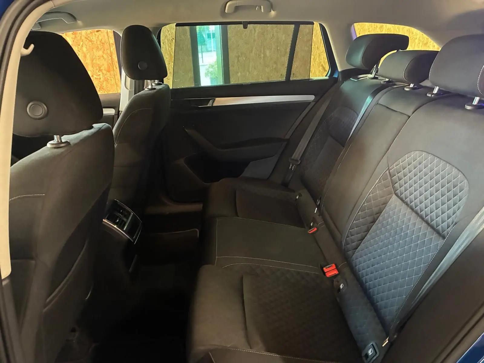 Vue intérieure côté droit des sièges arrière en tissu noir matelassé d'une Skoda Superb Combi 2021 bleu diesel.