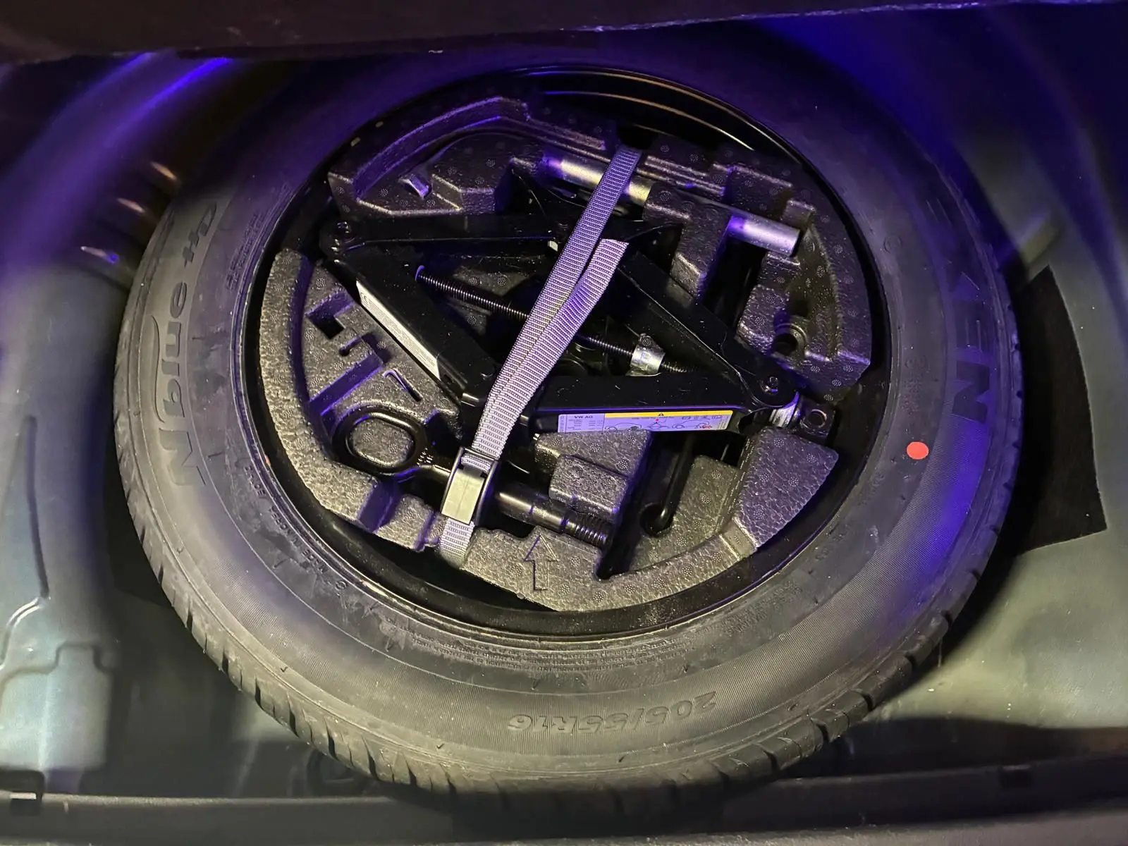 Roue de secours avec outils de changement dans le coffre d'une Skoda Superb Combi bleu 2021.