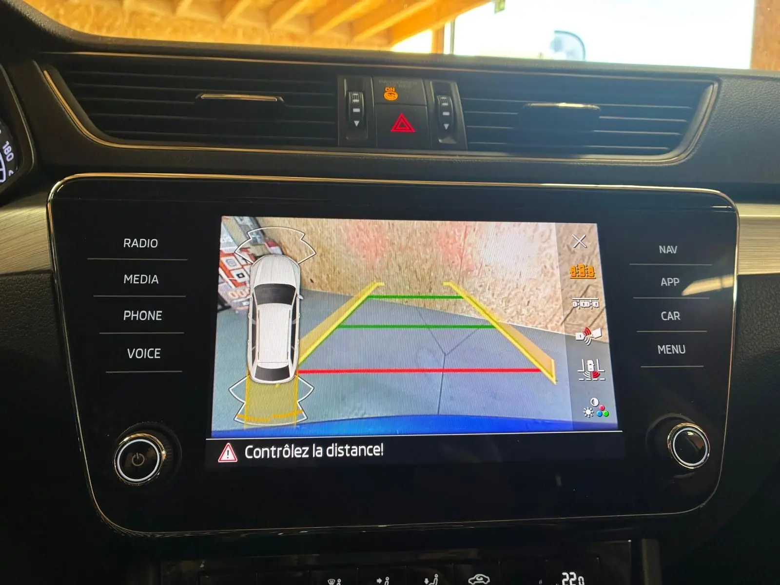 Écran central de la Skoda Superb Combi bleu 2021 montrant la caméra de recul avec guidage de trajectoire coloré.