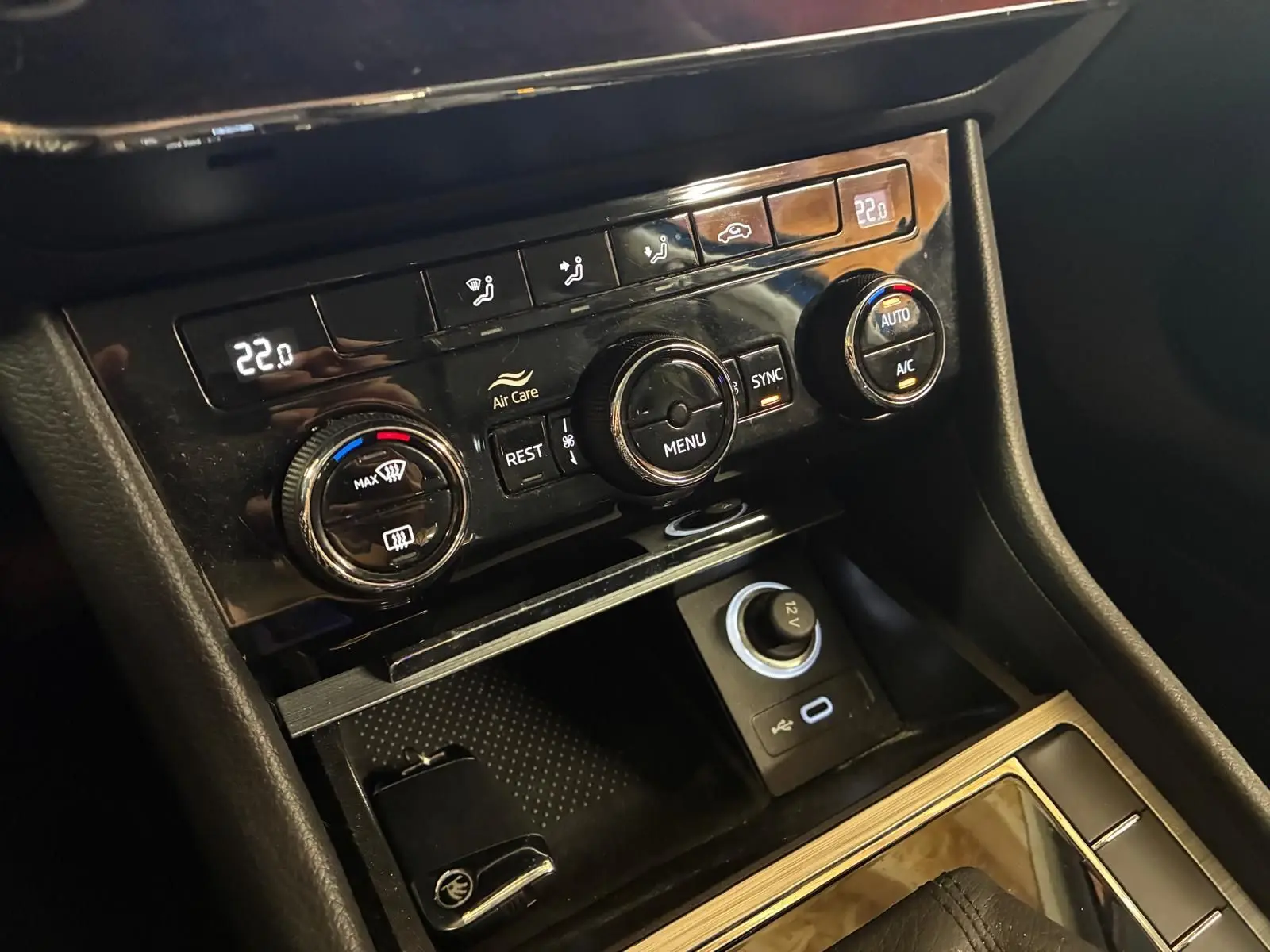 Gros plan sur la console centrale noire de la Skoda Superb Combi 2021, montrant les commandes de climatisation et prises USB et 12V.