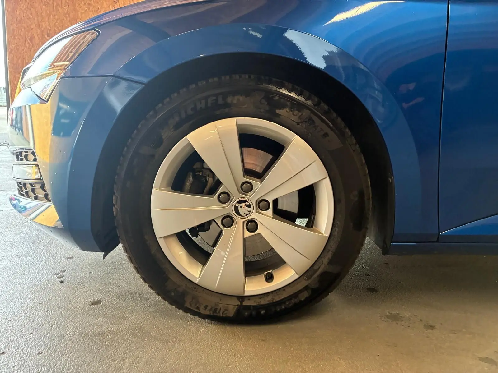 Gros plan sur la roue avant gauche d'une Skoda Superb Combi bleu 2021 avec jante alliage 17 pouces.