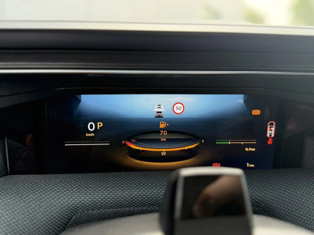 Affichage numérique du tableau de bord du Citroën C5 Aircross hybride montrant la vitesse, autonomie et alertes, vue de face.