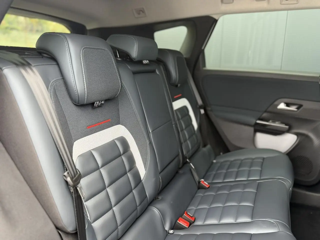 Vue latérale droite des sièges arrière en cuir noir et tissu gris du Citroën C5 Aircross 2026 avec détails rouges et ceinture de sécurité.