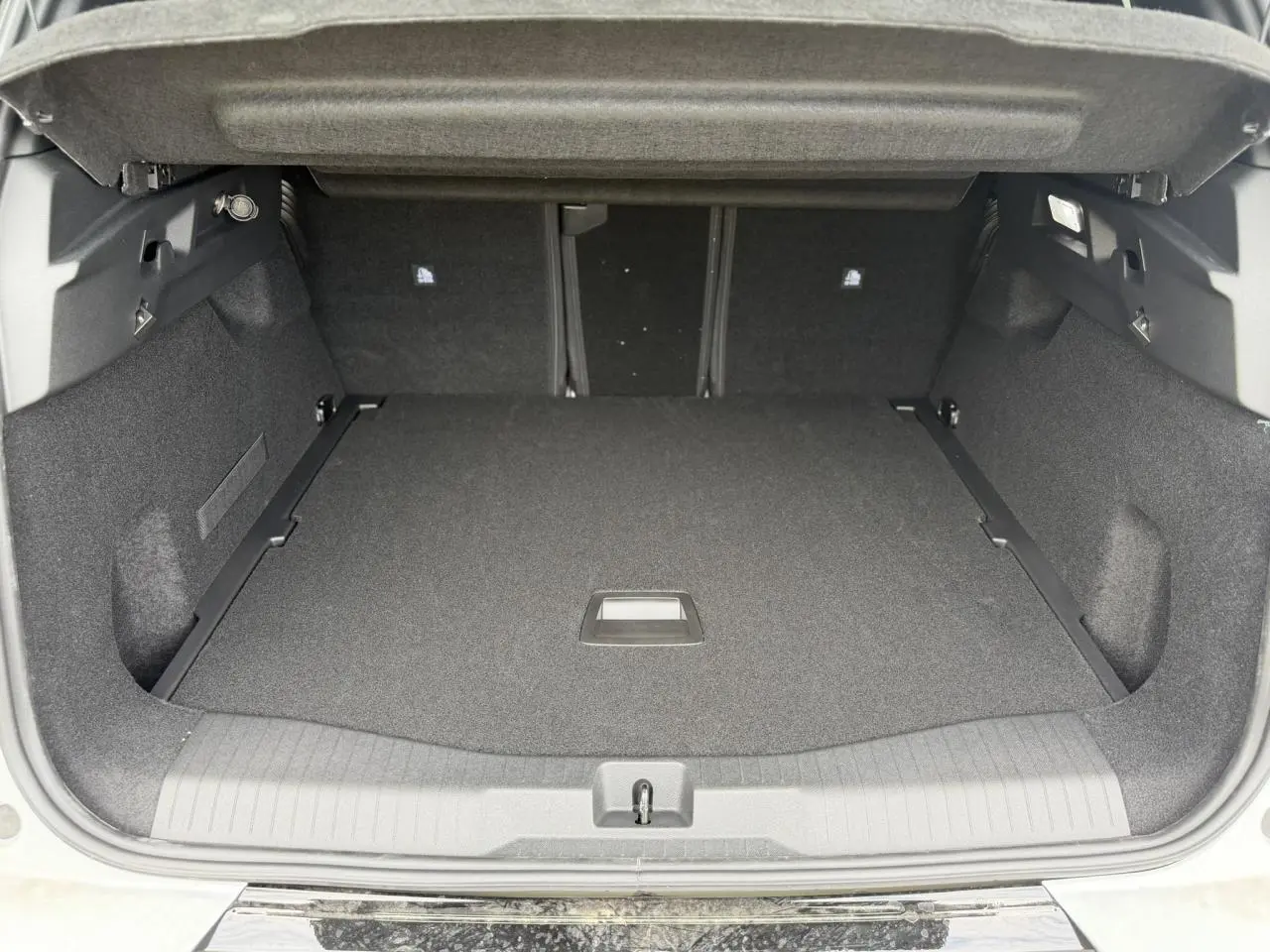 Coffre ouvert du Citroën C5 Aircross blanc, vue arrière montrant l'espace de chargement spacieux et propre.