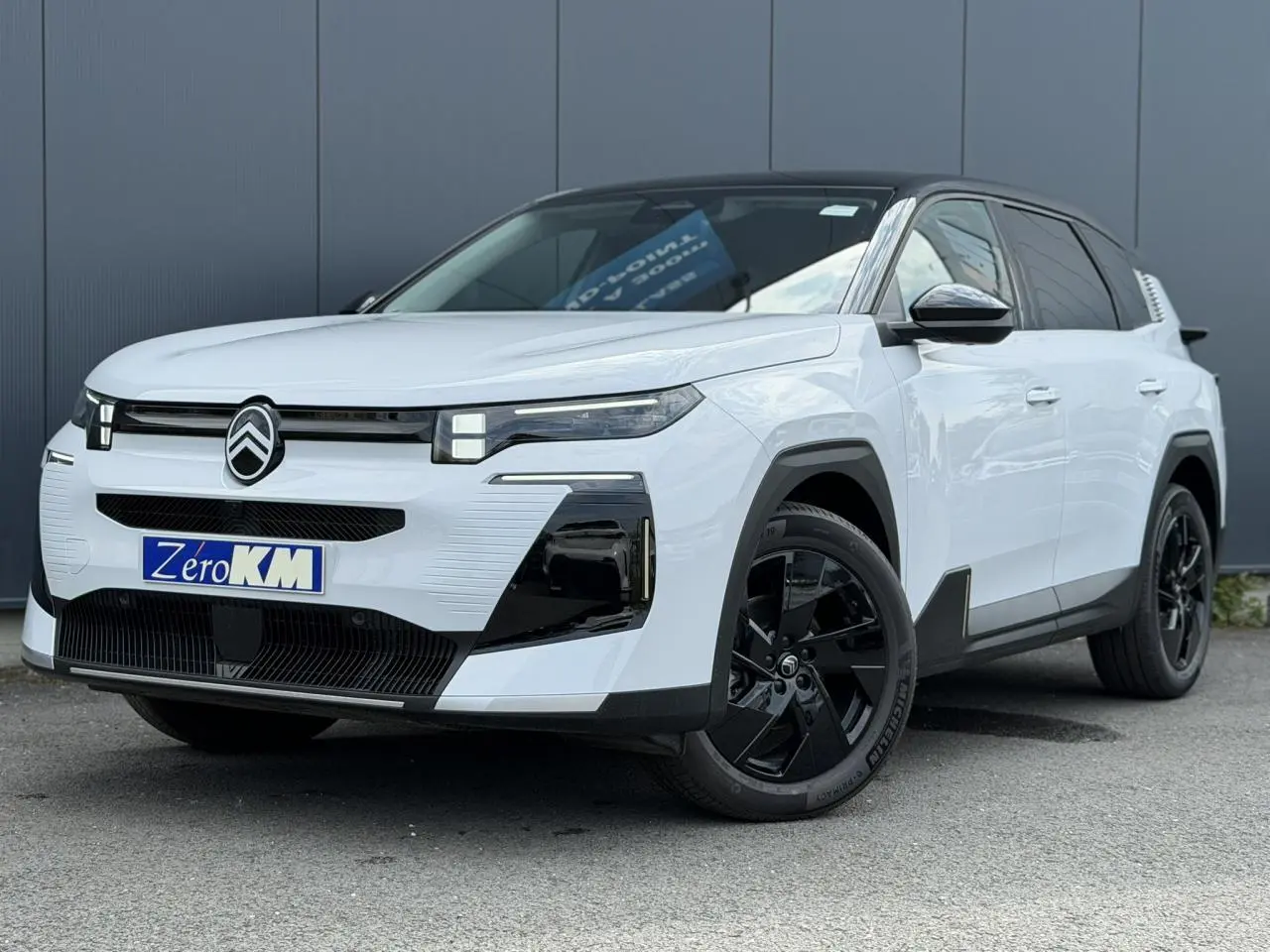Vue 3/4 avant d'un Citroën C5 Aircross blanc Okenite avec toit noir et jantes alliage noires.