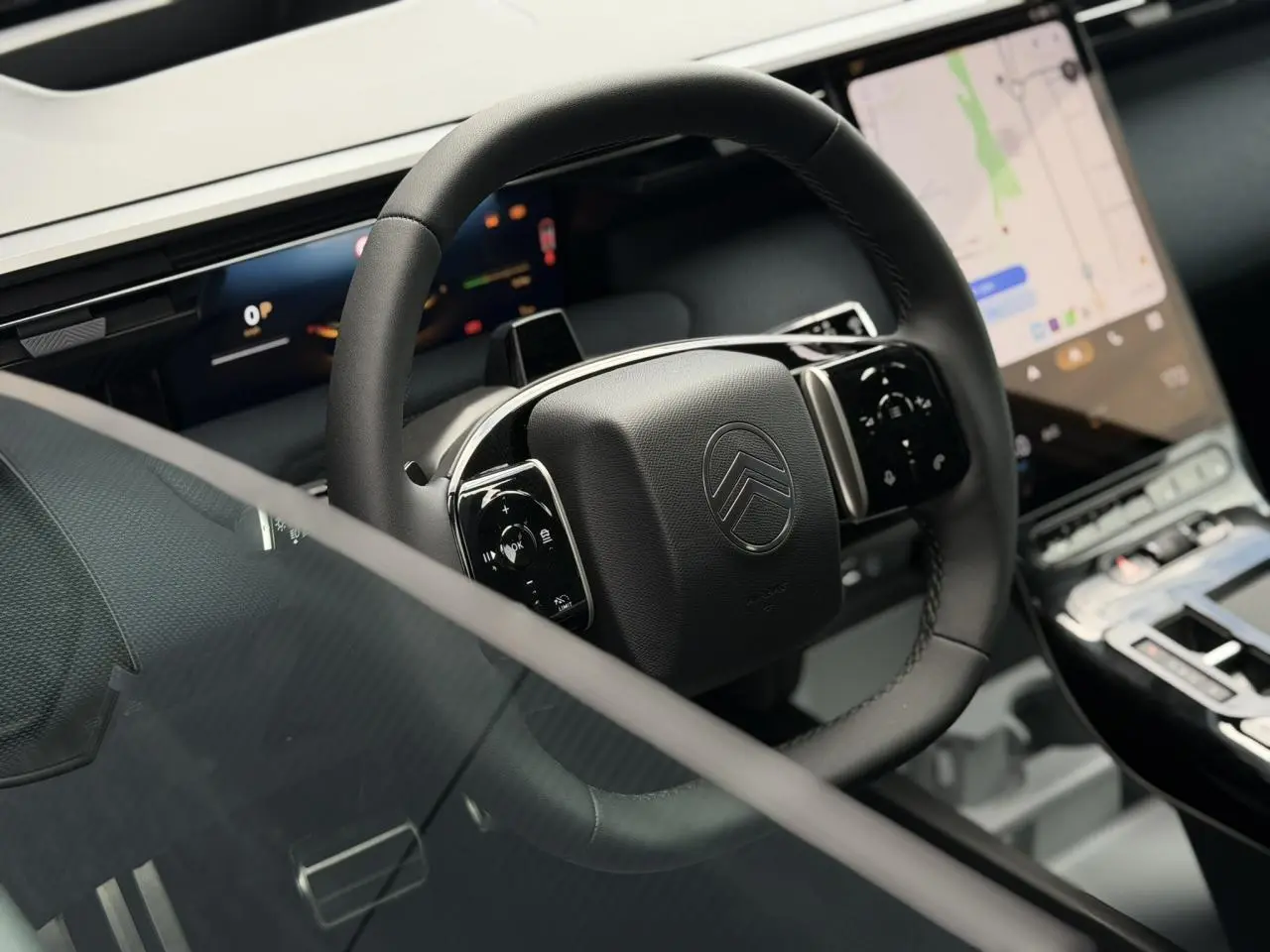 Vue rapprochée du volant noir mat et des écrans digitaux du tableau de bord du Citroën C5 Aircross hybride 2026.