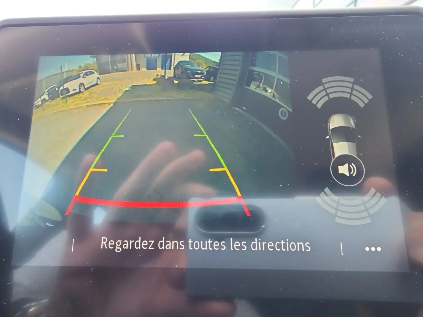 Vue de l'écran de la caméra de recul du Renault Captur noir, avec lignes de guidage colorées et alertes de proximité.