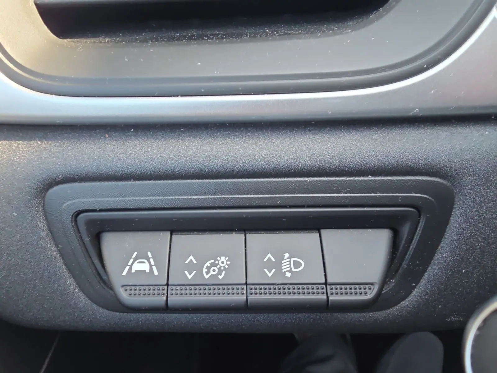Gros plan sur les commandes noires du tableau de bord du Renault Captur 2021, boutons d’aide à la conduite visibles.