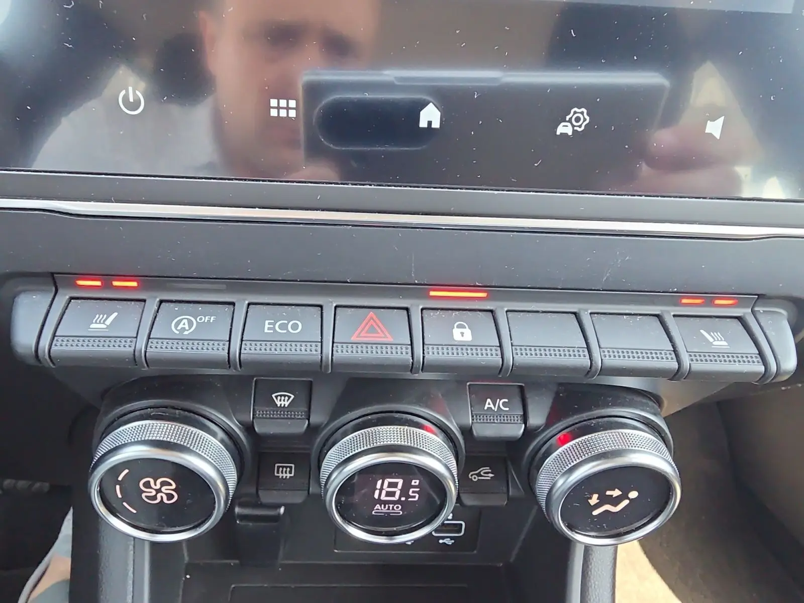 Vue rapprochée de la console centrale du Renault Captur noir, montrant les commandes de climatisation et sièges chauffants activés.