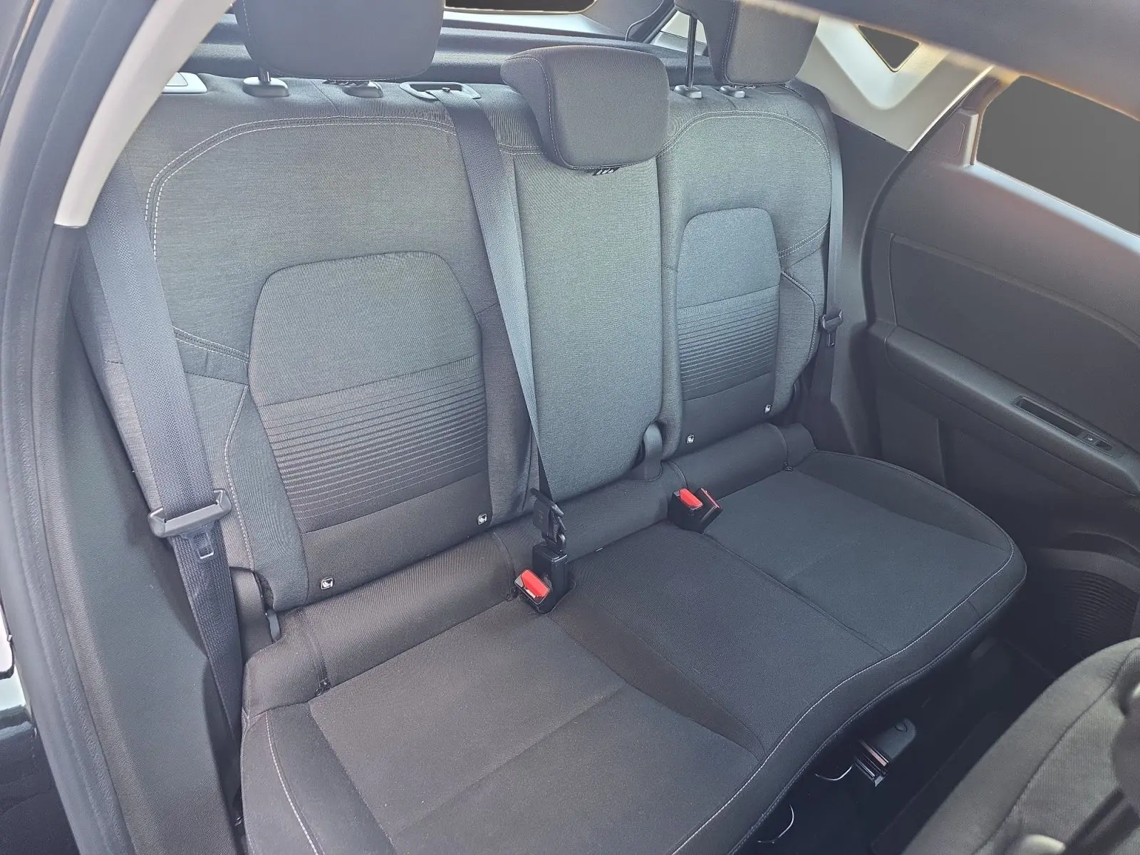 Vue intérieure sur la banquette arrière noire du Renault Captur 2021, avec ceintures de sécurité et appuie-têtes visibles.