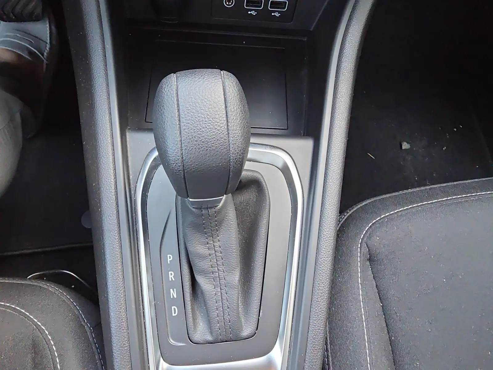 Le levier de vitesses automatique noir du Renault Captur 2021 vu de dessus, entouré de sellerie noire.