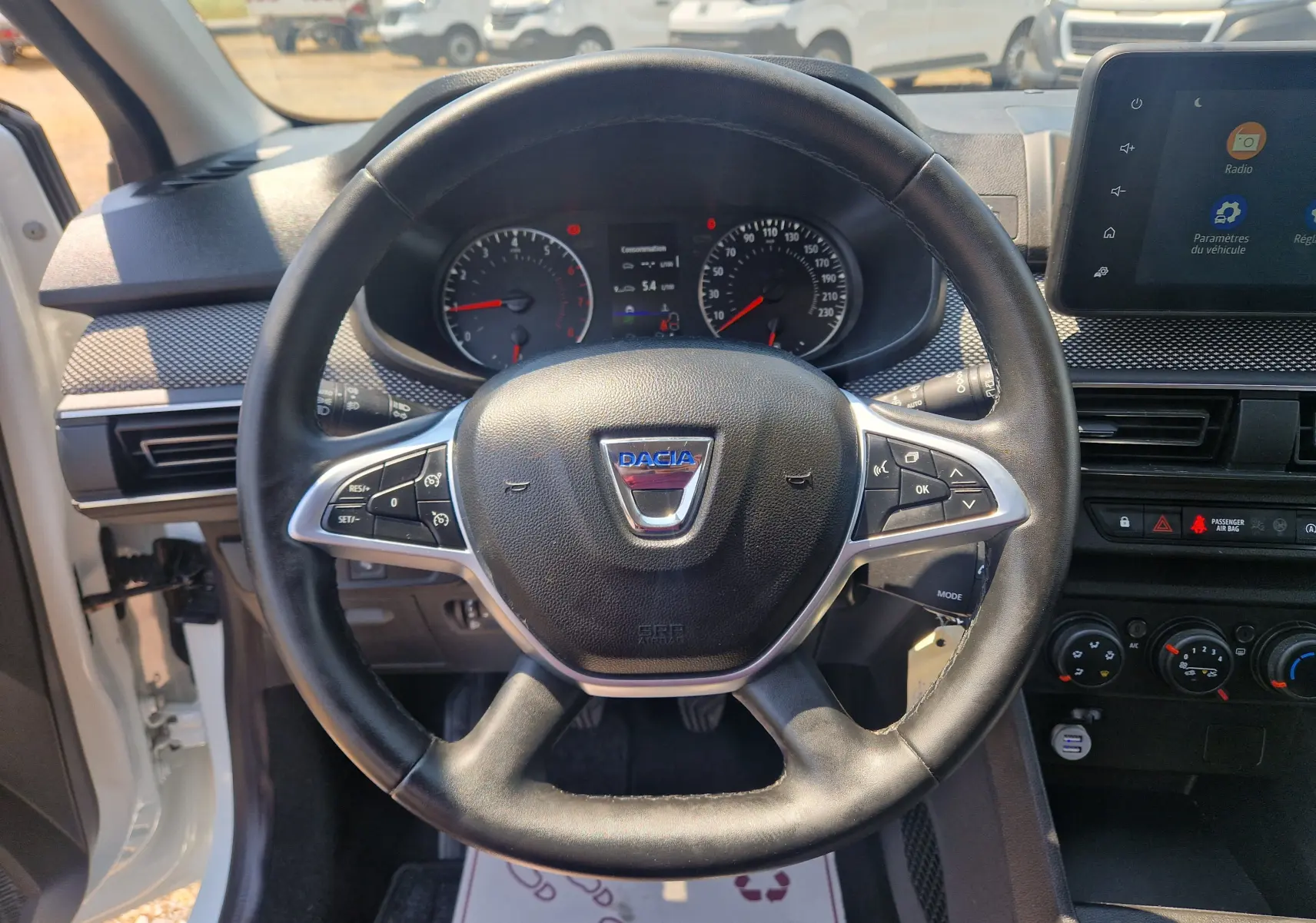 Vue frontale du volant noir de la Dacia Sandero 2022 avec tableau de bord et écran tactile visible.