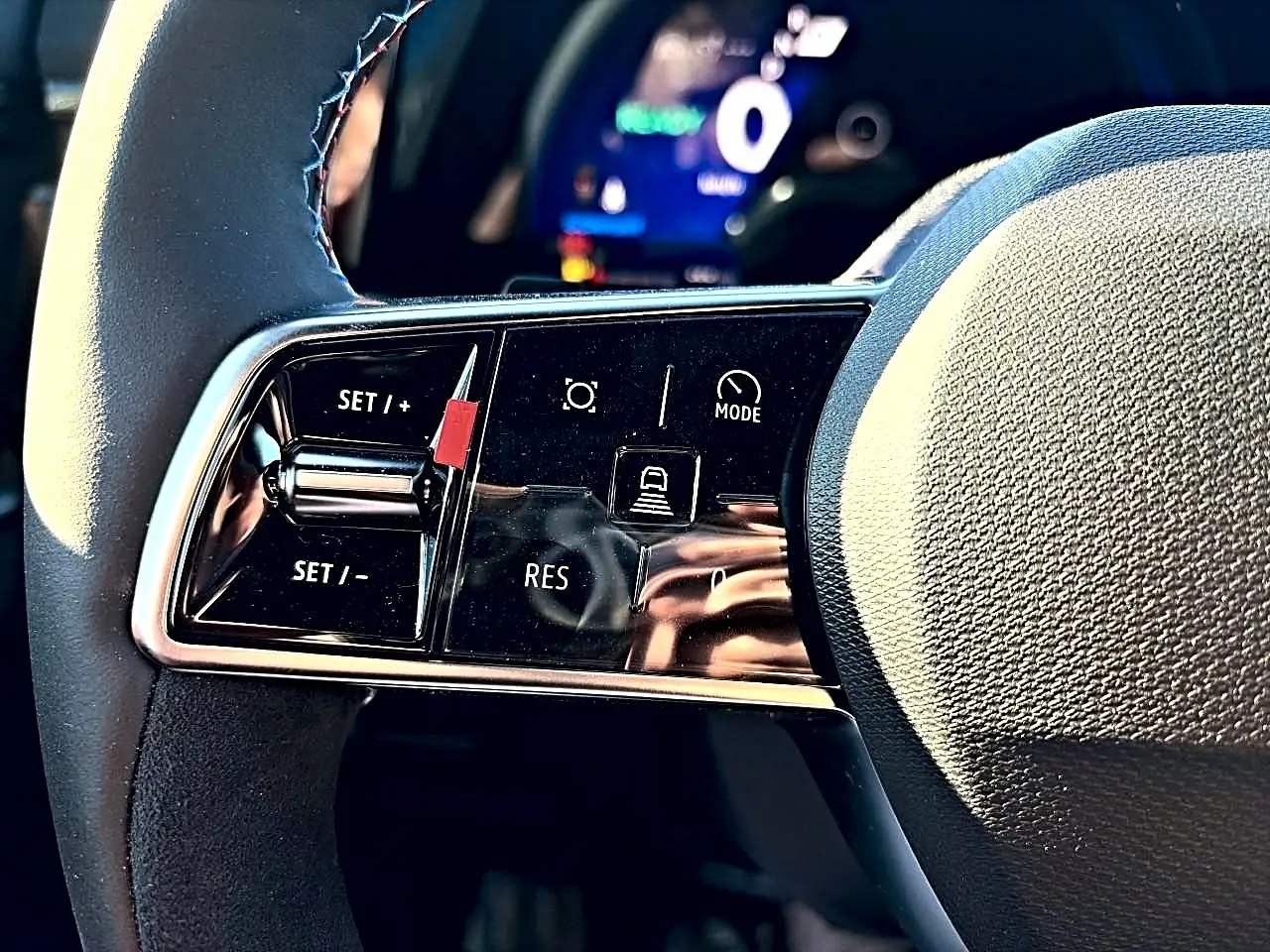 Gros plan sur les commandes de régulateur de vitesse au volant noir du Renault Austral 2026 esprit alpine.