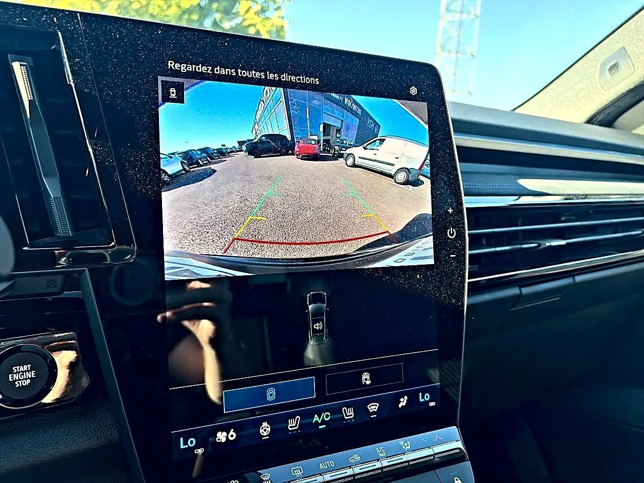 Écran tactile intérieur du Renault Austral noir montrant la caméra de recul avec vue arrière du parking.