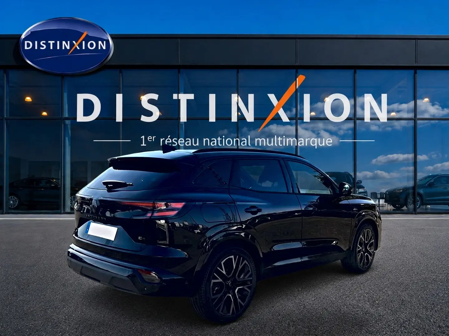 Renault Austral noir en 3/4 arrière droit, avec jantes alu et becquet arrière, devant vitrine Distinxion.