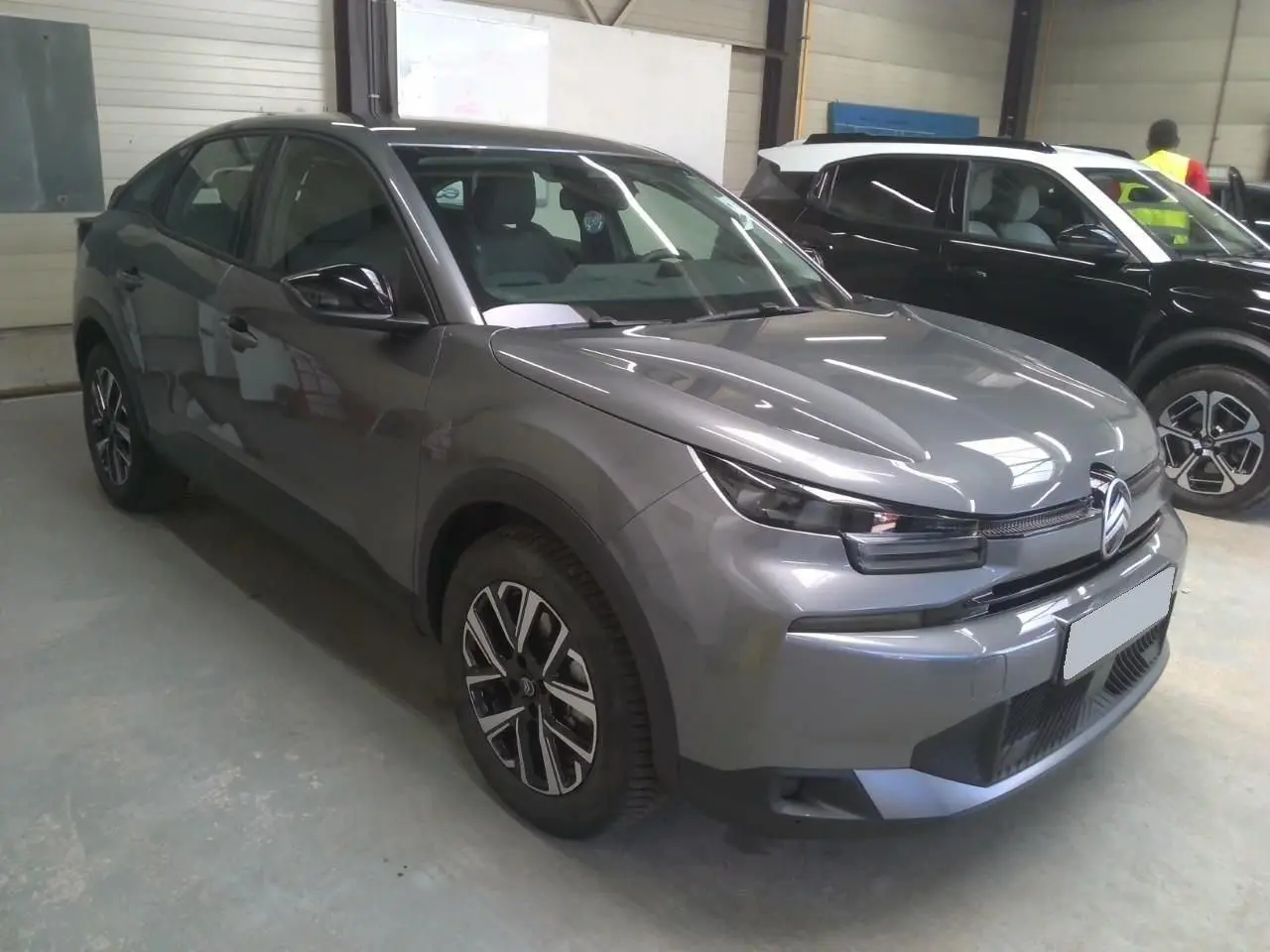 Citroën C4 hybride gris Mercury vue 3/4 avant droit, avec jantes bi-ton et phares LED distinctifs.