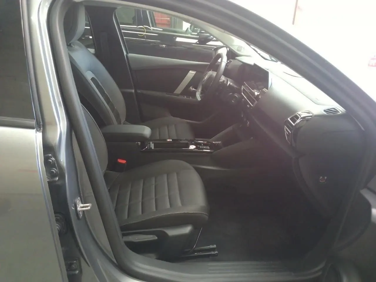 Intérieur avant droit de la Citroën C4 gris Mercury 2025, sièges noirs et tableau de bord moderne avec écran tactile.