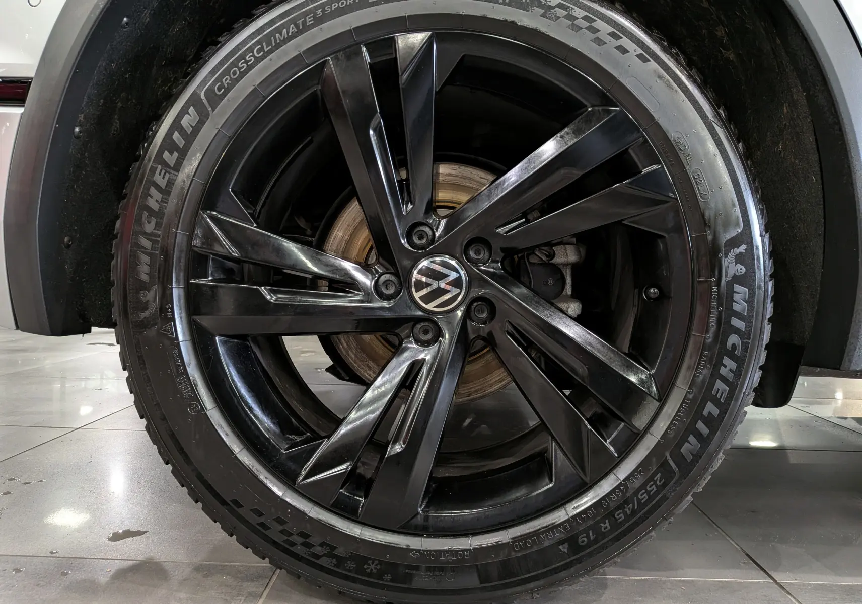 Gros plan sur la roue avant droite du Volkswagen Tiguan 2024, jante noire brillante et pneu Michelin CrossClimate.
