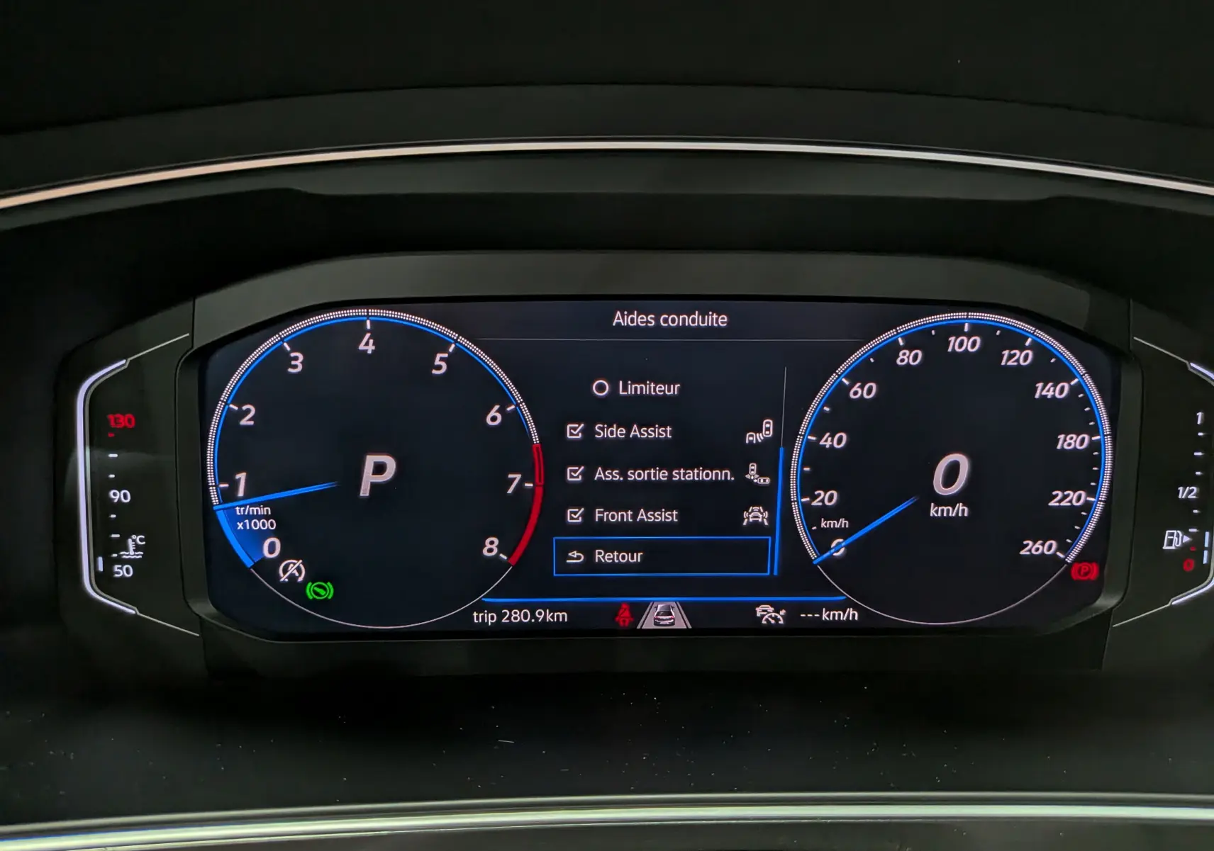 Vue rapprochée du tableau de bord numérique du Volkswagen Tiguan 2024 affichant les aides à la conduite activées.