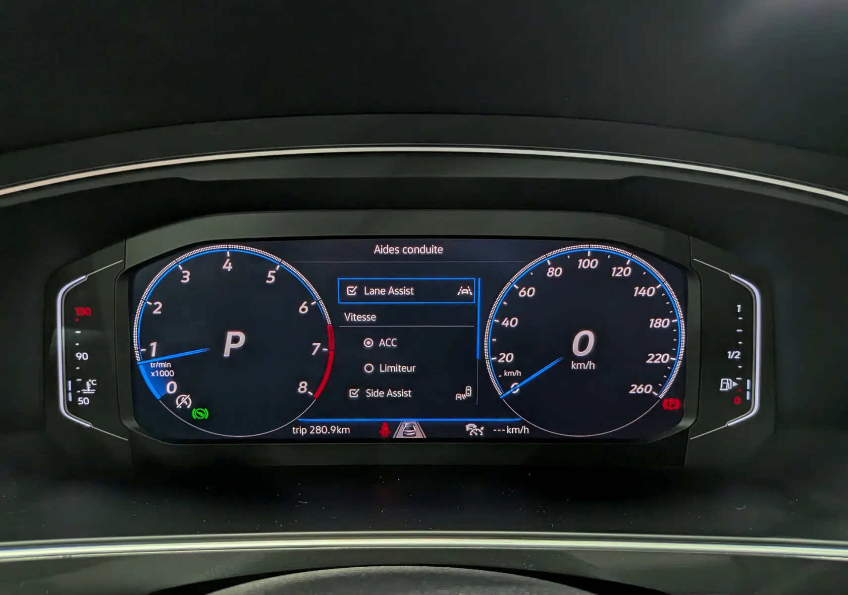 Affichage numérique du tableau de bord du Volkswagen Tiguan 2024, montrant les aides à la conduite activées.