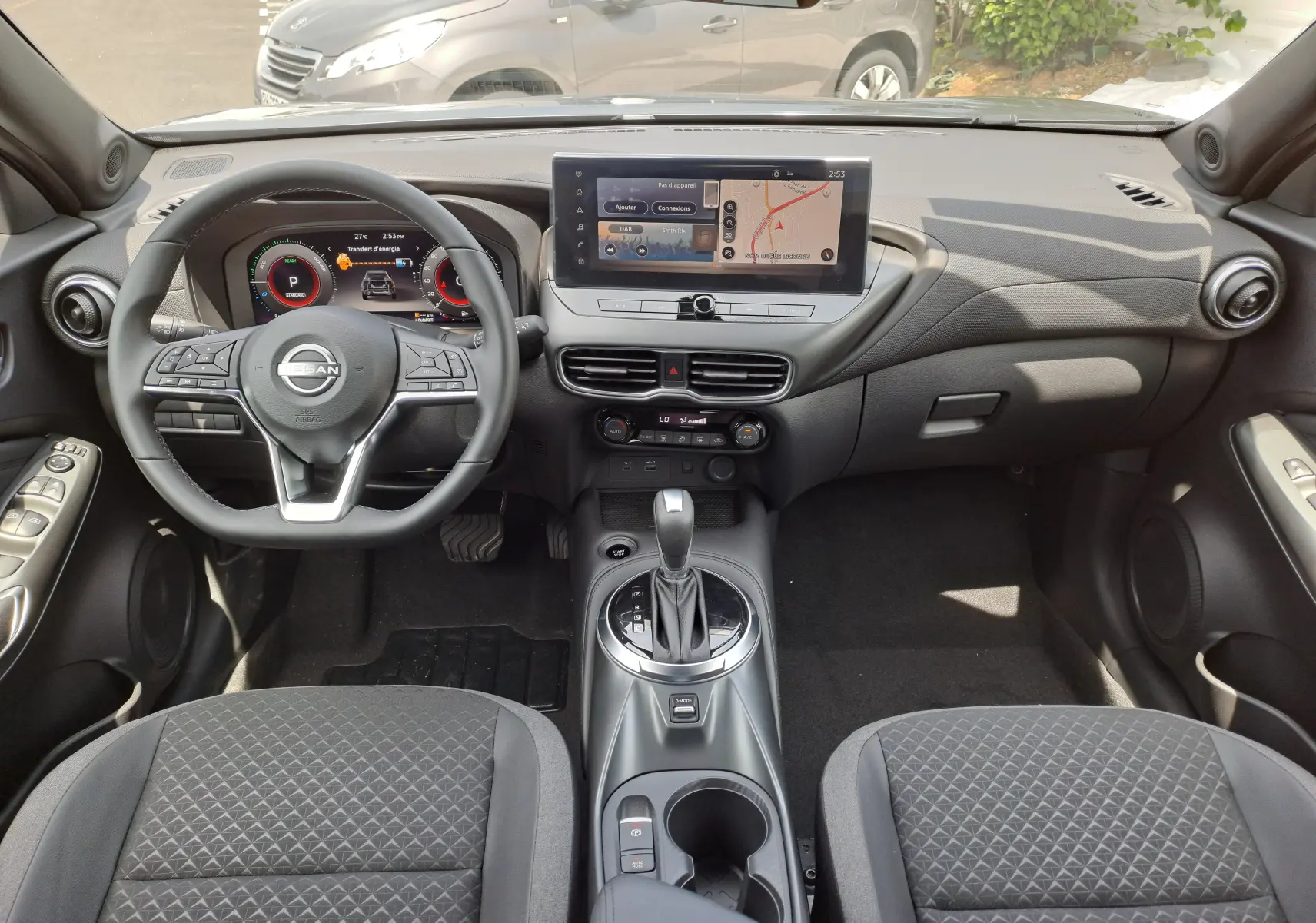 Vue intérieure avant du Nissan Juke Hybrid 143 N-Connecta 2025 avec tableau de bord numérique et écran tactile central.