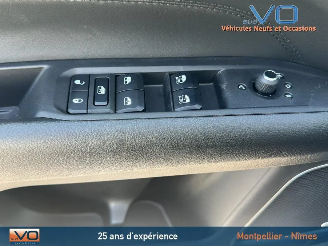 Gros plan sur les commandes de lève-vitres et réglage des rétroviseurs côté conducteur du Jeep Compass noir 2023.