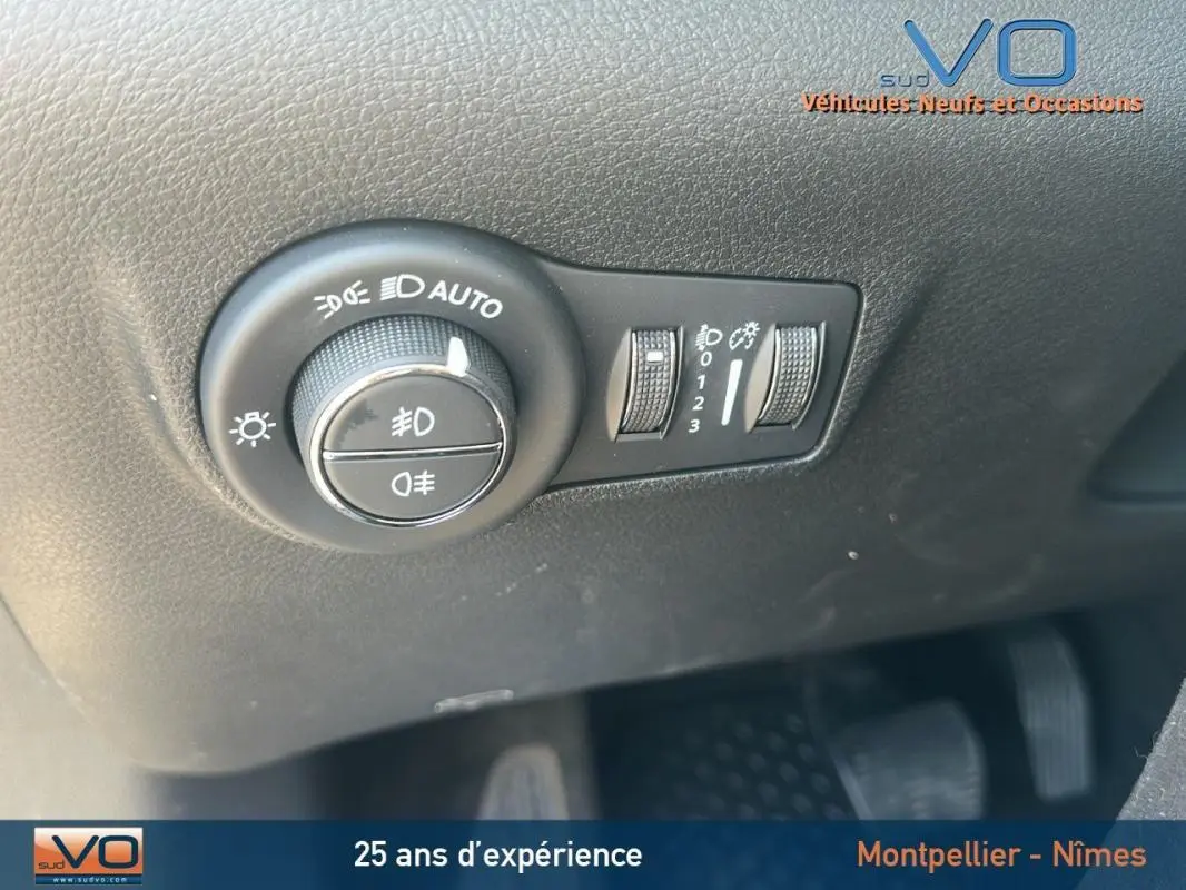 Gros plan sur les commandes d'allumage automatique des feux et réglage d'intensité lumineuse du Jeep Compass noir 2023.