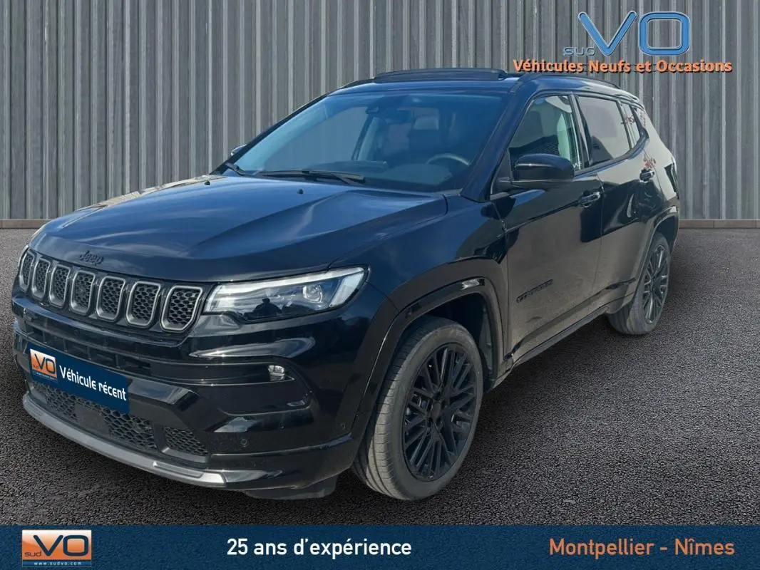 Jeep Compass noir en 3/4 avant droit, avec jantes alliage noires et toit ouvrant panoramique visible.
