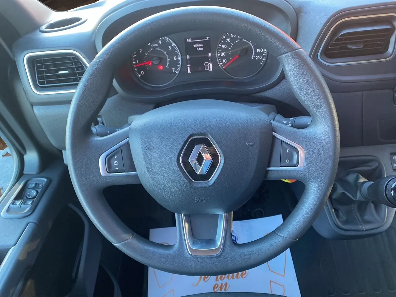 Volant Renault noir avec logo central, tableau de bord et levier de vitesses manuel visibles dans l'habitacle du Master Châssis Cabine blanc.