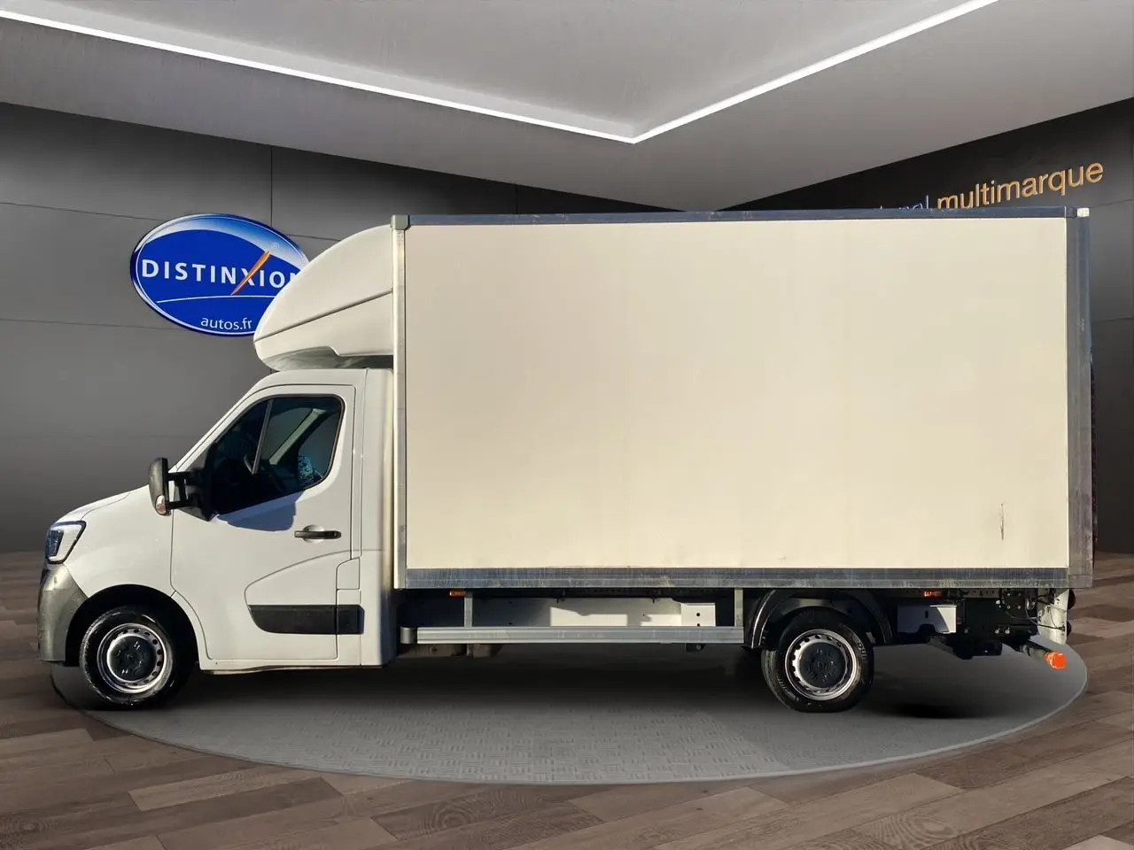 Profil gauche d'un utilitaire blanc Renault Master Châssis Cabine 2023 avec caisse fermée et hayon arrière visible.