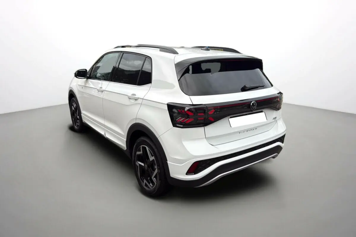 Vue 3/4 arrière droite du Volkswagen T-Cross blanc pur TSI 116 DSG7 R-Line avec jantes alu noires et vitres surteintées.