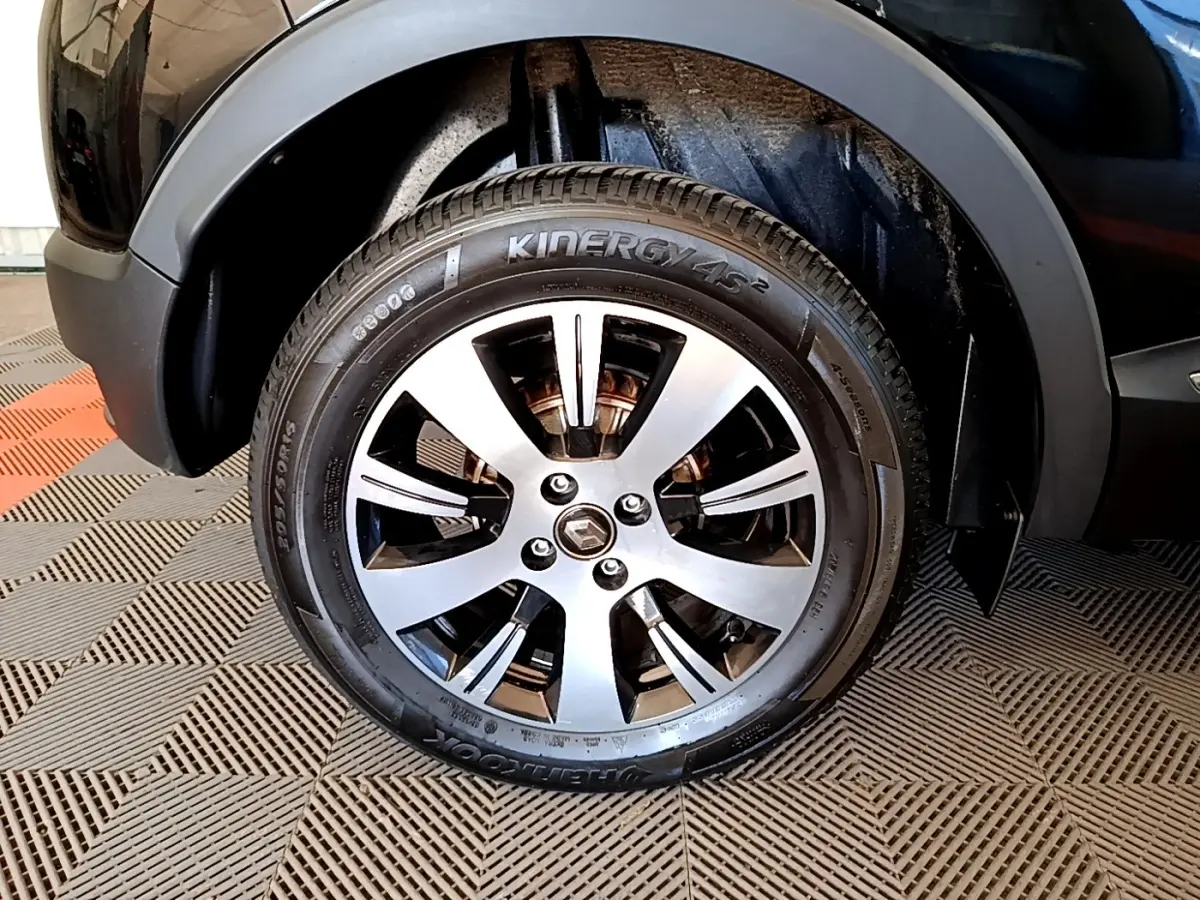 Gros plan sur la roue avant droite noire du Renault Captur Business TCe 90 avec jante alliage argentée et pneus Kinergy.