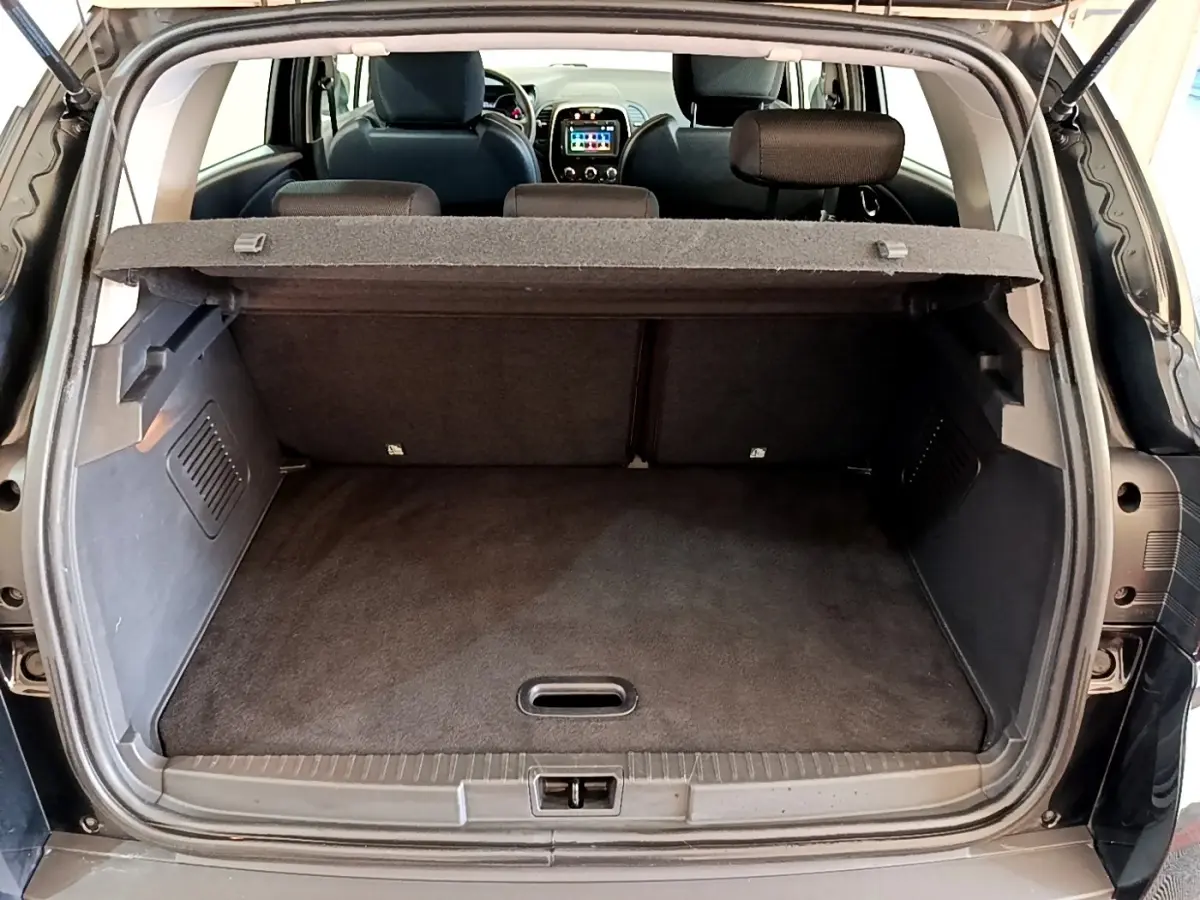Coffre ouvert vu de l'arrière d'un Renault Captur Business TCe 90 noir, avec tablette cache-bagages en place.