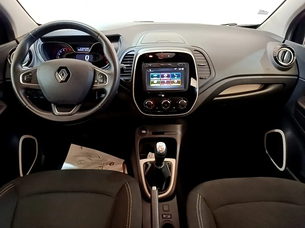 Vue intérieure avant du tableau de bord noir du Renault Captur Business TCe 90 avec écran tactile et volant cuir multifonctions.