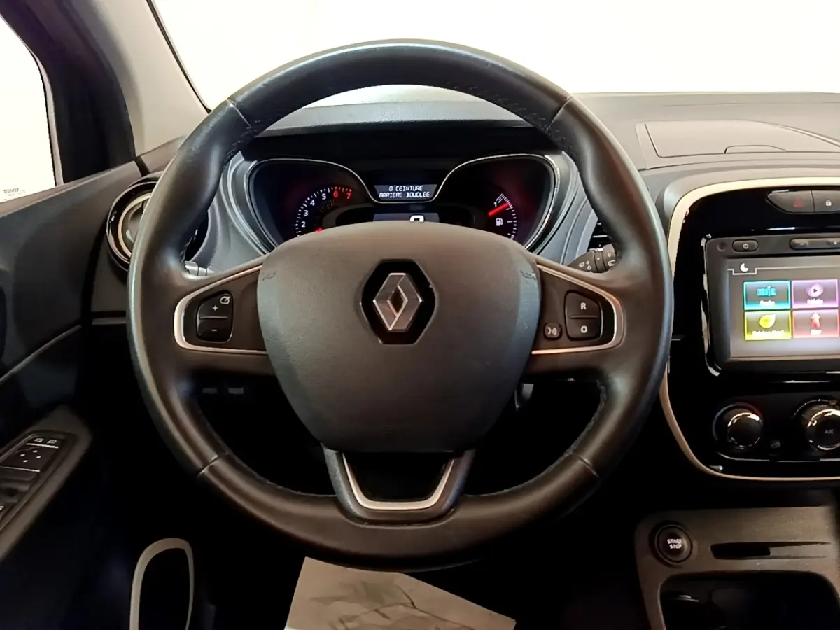 Vue intérieure centrée sur le volant cuir noir de la Renault Captur Business 2018 avec tableau de bord et écran tactile.
