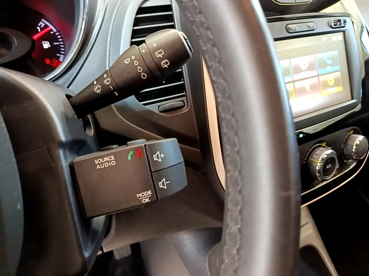 Vue rapprochée du volant noir et des commandes audio sur le côté gauche du tableau de bord du Renault Captur Business 2018.