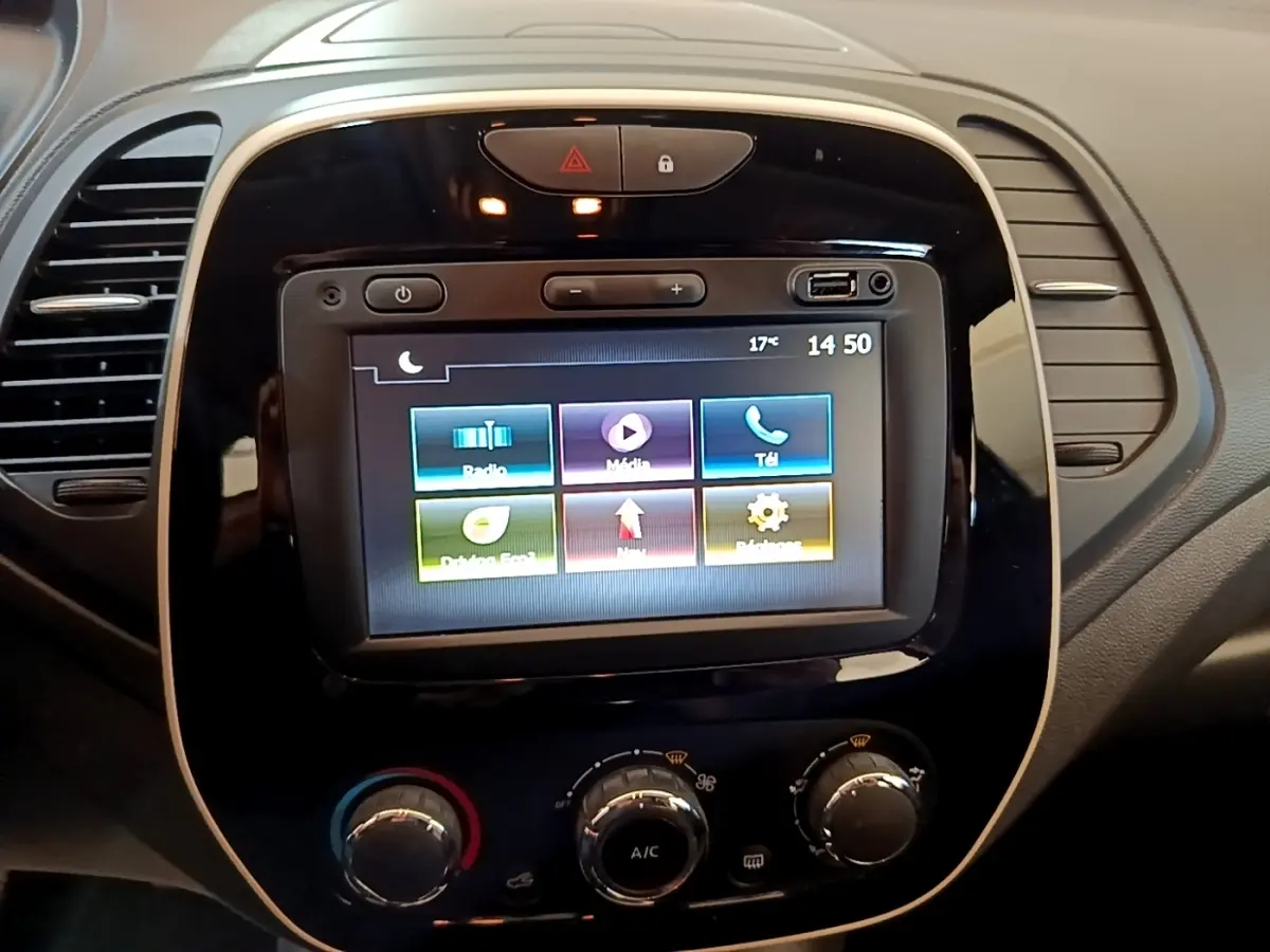 Vue rapprochée du tableau de bord noir du Renault Captur Business 2018 avec écran tactile central allumé et commandes de climatisation.