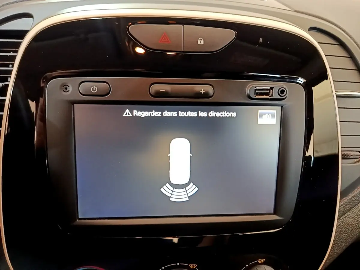 Écran tactile noir du tableau de bord Renault Captur Business 2018 affichant l'alerte de surveillance des angles morts.