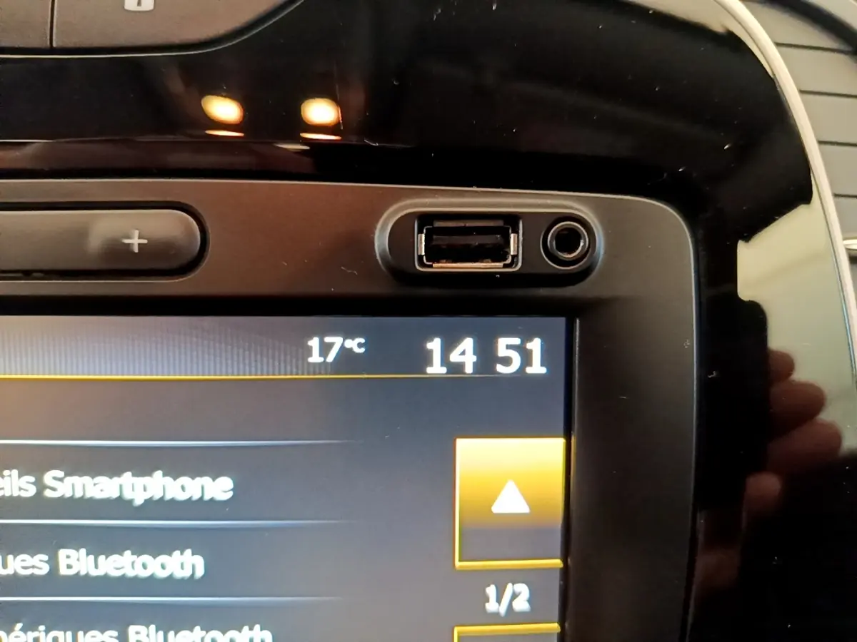 Gros plan sur l'écran tactile noir du tableau de bord du Renault Captur Business TCe 90, affichant l'heure et la température.
